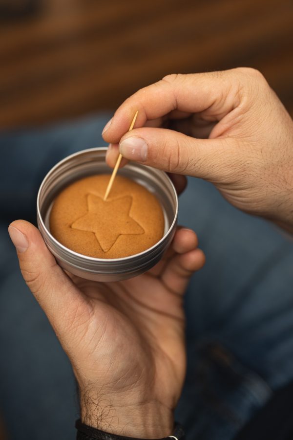 Dalgona cookie. Korean cookie from Squid Game. Korean Game. Boys Hand Playing Dalgona Ppopgi Candy.